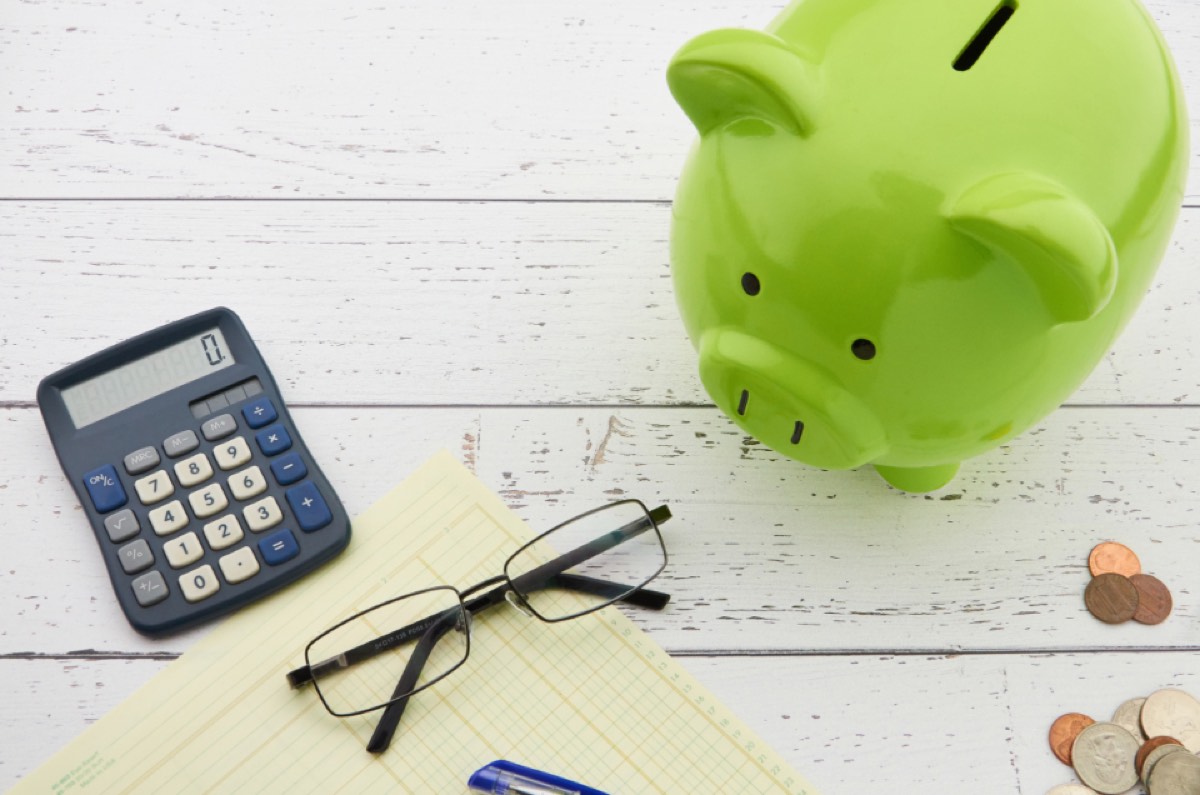 Piggy bank, calculator and coins — budgeting to rent a room