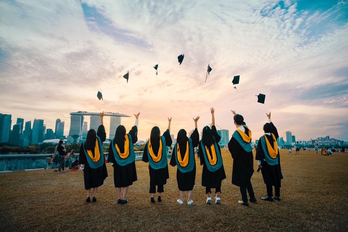 University students throwing graduation caps in the air